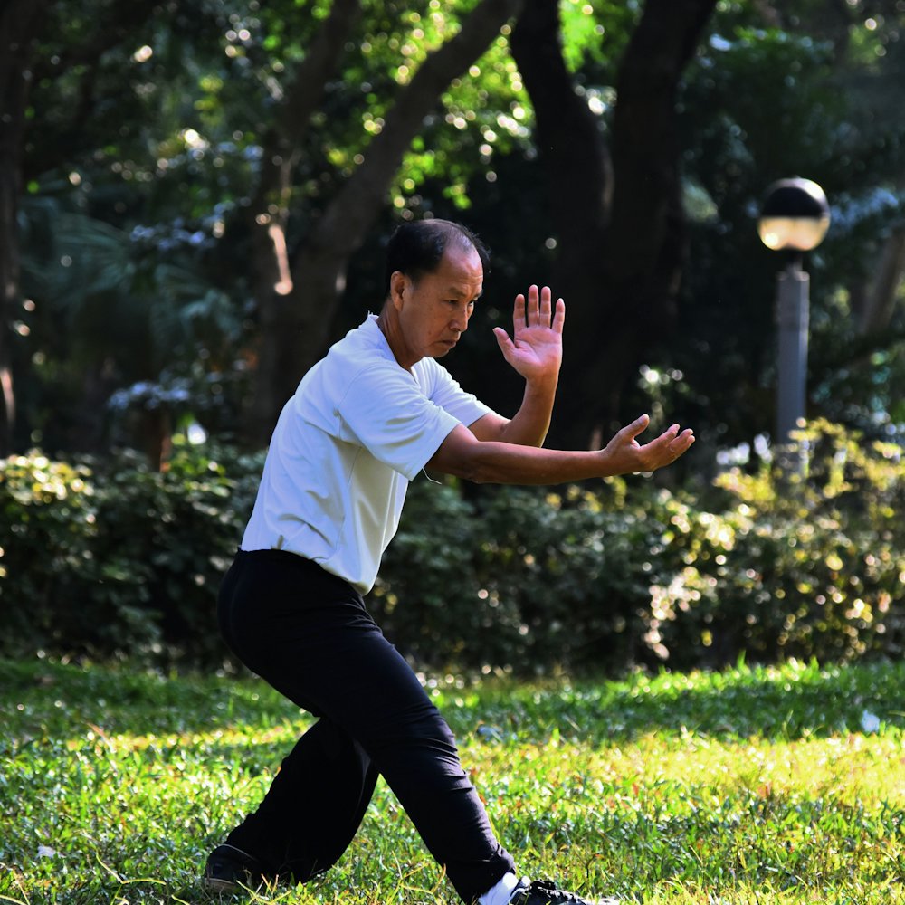 Mężczyzna ćwiczący qigong w zielonym parku
